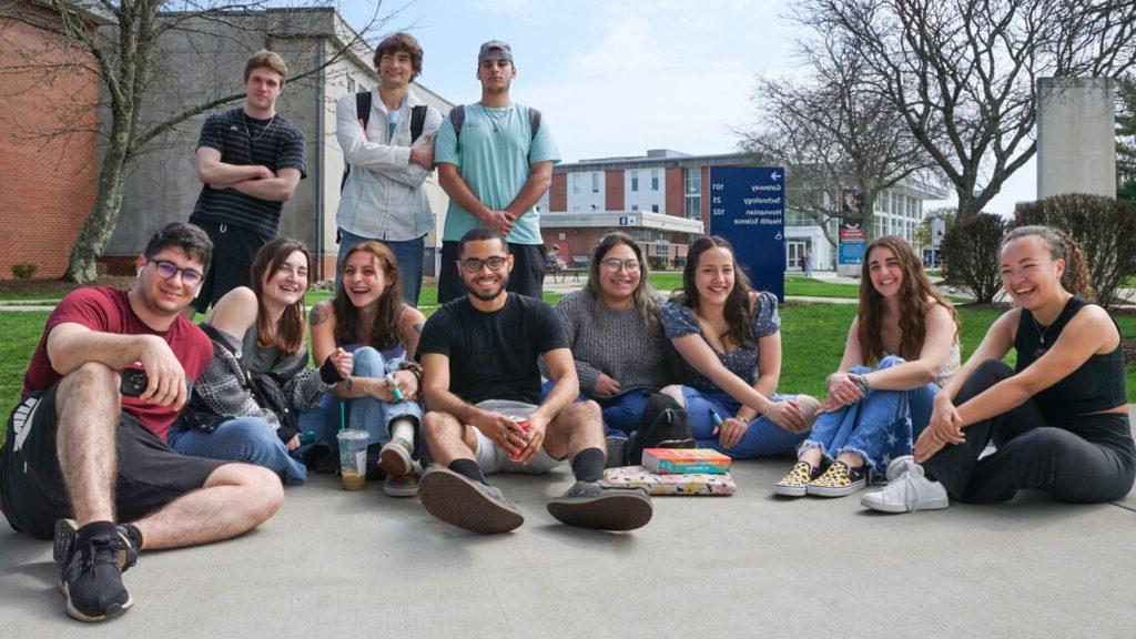 group of students sitting in the campus mall posing for an image